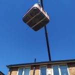 Hot Tub Being Lifted into a garden with a crane